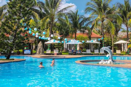 una piscina in un resort con persone in acqua di Malibu Resort a Mui Ne