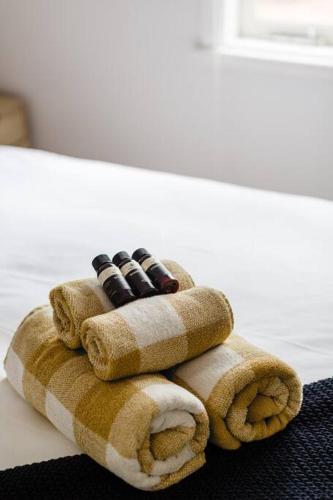 a stack of four remote controls sitting on a towel at The Happy Home – a classic Margs Experience in Margaret River Town