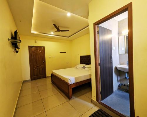 a bedroom with a bed and a sink and a ceiling at Hotel Prakash Residency with EV Station in Tiruchchirāppalli