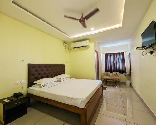 a bedroom with a bed and a ceiling fan at Hotel Prakash Residency with EV Station in Tiruchchirāppalli