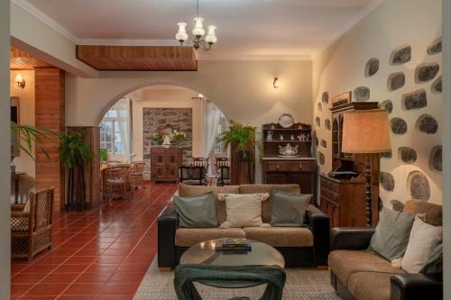 a living room with a couch and a table at Casa da Fajã Alta with breakfast by An Island Apart in Jogo da Bola