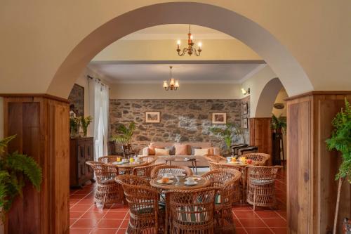 een boog met tafels en stoelen in een kamer bij Casa da Fajã Alta with breakfast by An Island Apart in Jogo da Bola