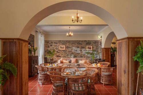 an archway with tables and chairs in a room at Casa da Fajã Alta with breakfast by An Island Apart in Jogo da Bola