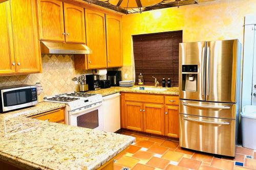 a kitchen with wooden cabinets and a stainless steel refrigerator at Beautiful Spanish-Styled Home in Fresno