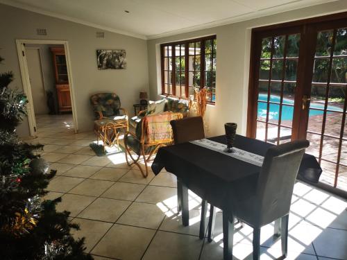 a dining room with a table and chairs and a pool at Parkers Cottages in St Lucia