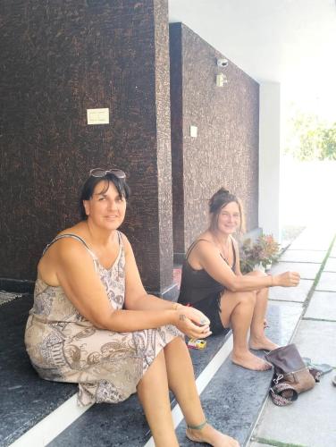two women sitting on the steps of a building at Bachan's Casa in Cherai Beach
