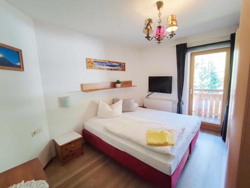 een slaapkamer met een bed, een tv en een raam bij Scenic Holiday Home in Ramsau with Garden Barbeque in Hippach