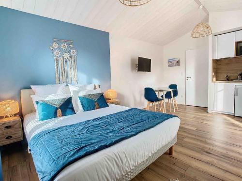 a bedroom with a large bed with a blue wall at La Tranquillité in LʼHerbaudière