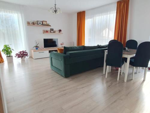 a living room with a green couch and a table at River park CB in Reghin