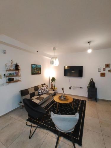 a living room with a couch and a table at Amazing Tower apt at karmei Gat- perfect familly vacation in Qiryat Gat