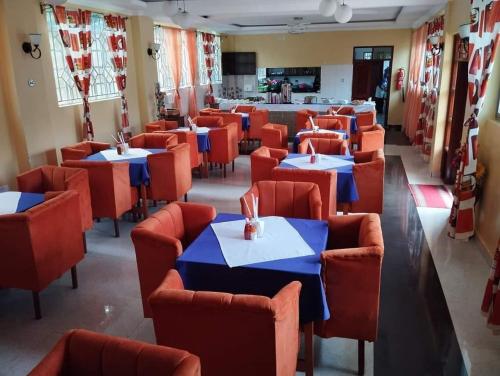 a restaurant with blue tables and red chairs at Villa Martis Kakamega in Kakamega