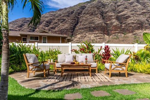 a patio with a table and chairs and a mountain at @Marbella Lane-Pōmaika'i LoveNest Ocean+MT View in Waianae