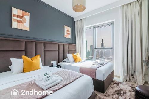 a hotel room with two beds and a large window at Direct Access to Dubai Mall, Downtown Views II T1 in Dubai