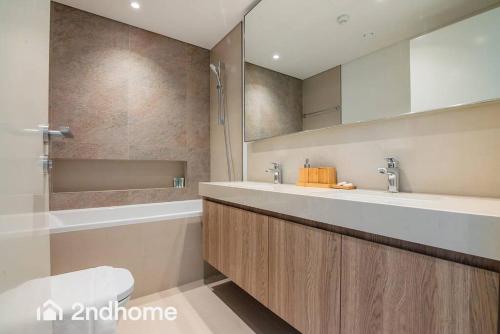a bathroom with two sinks and a toilet and a mirror at Direct Access to Dubai Mall, Downtown Views II T1 in Dubai