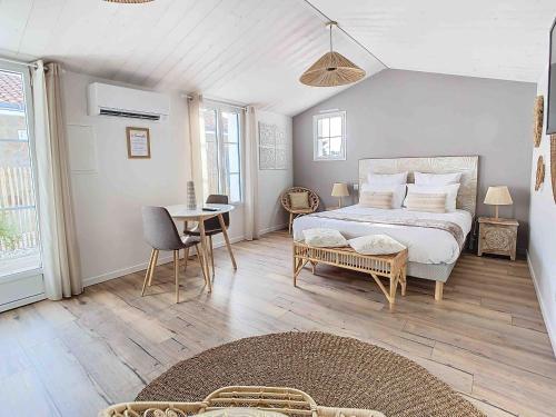 a bedroom with a bed and a table and chairs at La Tranquillité in LʼHerbaudière