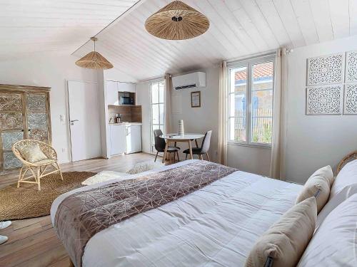 a bedroom with a large bed and a table at La Tranquillité in LʼHerbaudière