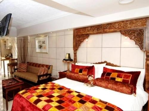 a bedroom with a large bed and a couch at Jane's Guesthouse in Saldanha