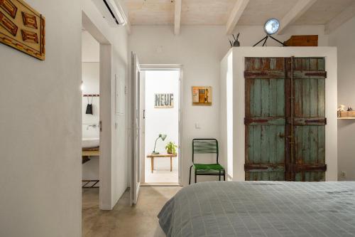 聖布拉什德阿爾波特爾的住宿－almóada - Eclectic Boutique Home，一间卧室设有绿门和一张书桌