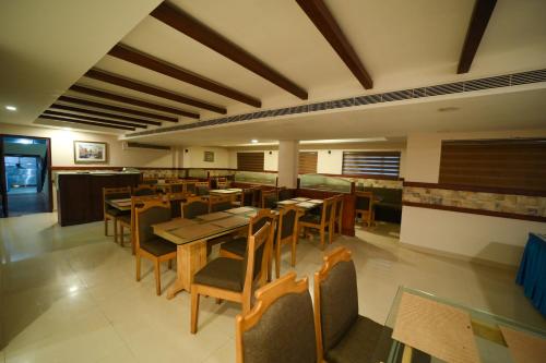 a dining room with wooden tables and chairs at HOTEL SKY PARK in Mattanūr
