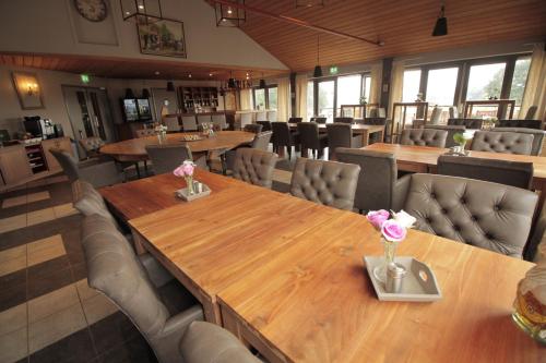a dining room with wooden tables and chairs at Human & Horse Hotel in Kootwijkerbroek