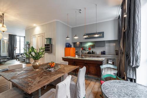 Il comprend une cuisine et une salle à manger avec une table en bois. dans l'établissement The Cosmopolitan Lodge, à Cannes