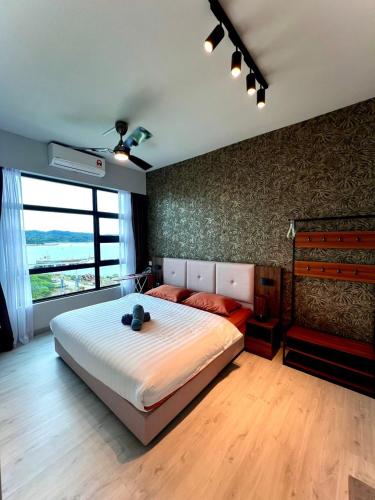 1 dormitorio con cama grande y ventana grande en CASA ABODE - Jesselton Quay (Sea View) en Kota Kinabalu