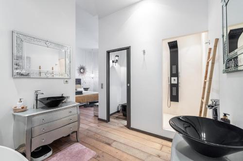 une salle de bain avec un lavabo noir et un miroir dans l'établissement The Cosmopolitan Lodge, à Cannes
