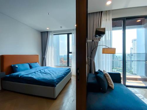 ein Schlafzimmer mit einem blauen Bett und einem großen Fenster in der Unterkunft Zeus Living - Lumiere Residence in Ho-Chi-Minh-Stadt