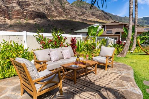 a patio with a couch and two chairs and a table at @Marbella Lane-Pōmaika'i LoveNest Ocean+MT View in Waianae
