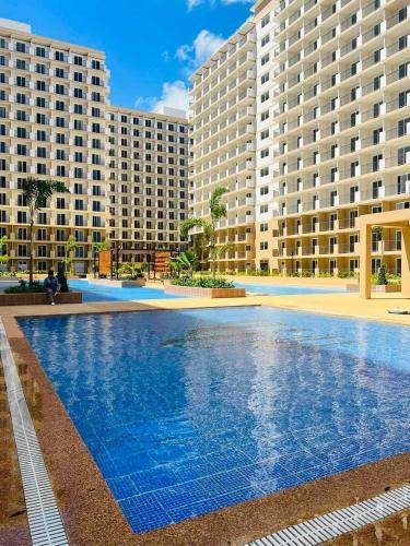a large swimming pool in front of two large buildings at RnB Stayction in Lapu Lapu City