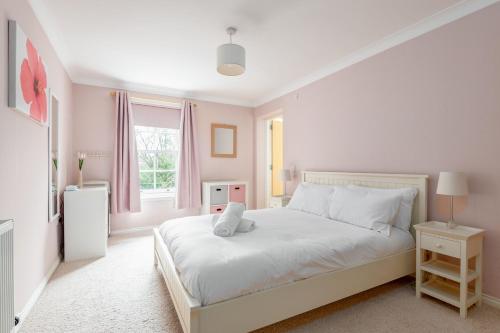 a white bedroom with a white bed and a window at Southgait Hall - No 17 in St. Andrews
