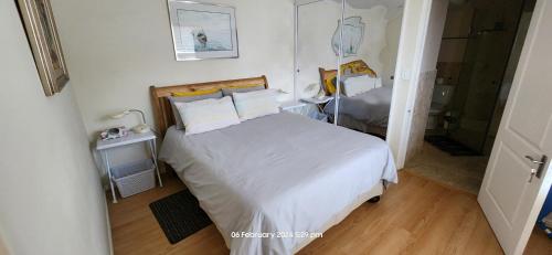 a bedroom with a bed with white sheets and pillows at 220 Loop St. Cape Town CBD in Cape Town