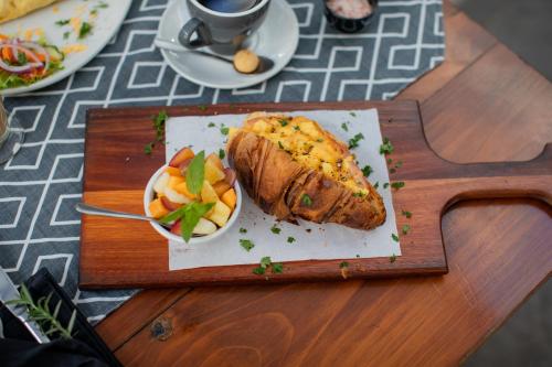 Un plato de comida en una mesa con un trozo de carne y fruta. en Aan de Eike Guest House, en Swellendam