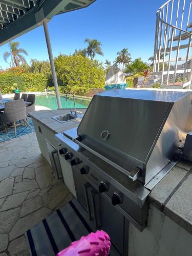 a grill on a patio with a pool in the background at La Playa Place Getaway in San Diego