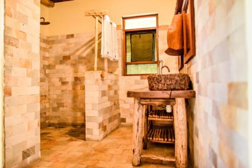a bathroom with a sink and a mirror at Tabingi Safari Cottages in Katunguru
