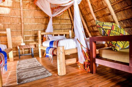 Tabingi Safari Cottages في Katunguru: غرفة بسرير وكرسي في غرفة