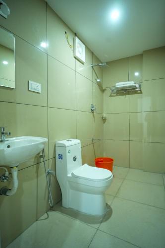 a bathroom with a toilet and a sink at PIOUS B RESIDENCY in Mundakāyam