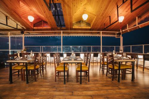 un restaurante con techos de madera, mesas y sillas en Zip By Spree Hotels Gangtok en Gangtok