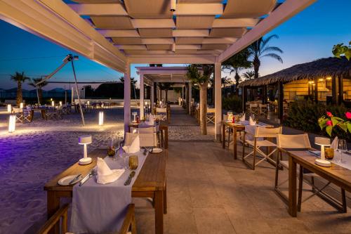 a restaurant on the beach with tables and chairs at Kempinski Hotel The Dome Belek in Belek