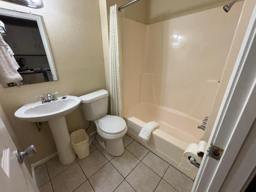 uma casa de banho com um lavatório, um WC e uma banheira em Cook's Motel em Panama City Beach