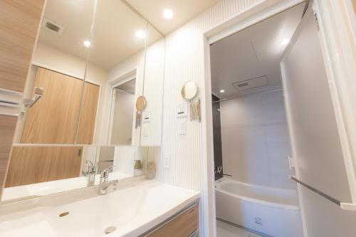 ein Badezimmer mit Waschbecken und Spiegel in der Unterkunft COSTA AKEBONO -Blanciera Naha Akebono Premist 1103- in Naha