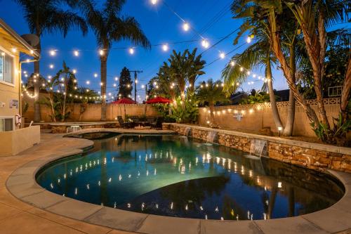 a swimming pool in a backyard at night with lights at Amazing Modern Pool House near Disneyland in Anaheim