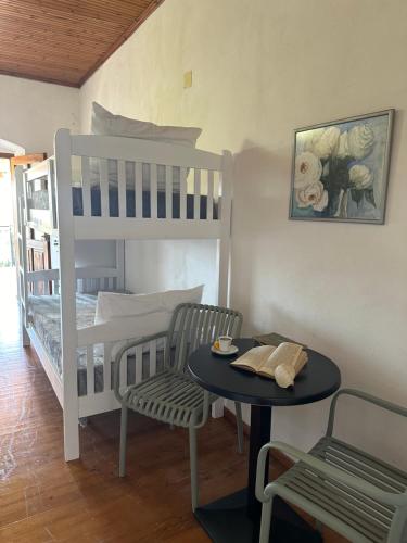 a bedroom with a bunk bed and a table and a table and chairs at Hostel on the Hill - by Filikuri Beach in Himare