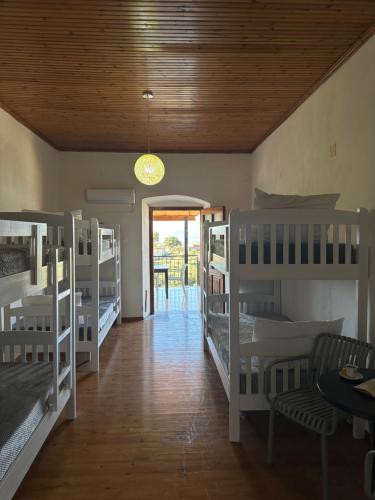 a room with four bunk beds and a hallway at Hostel on the Hill - by Filikuri Beach in Himare