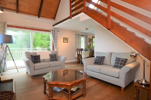 a living room with two couches and a table at Alder Cottage in Blairmore