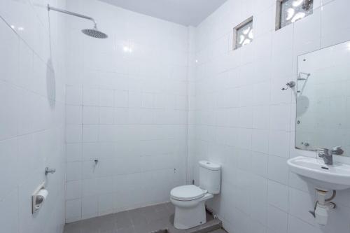 a white bathroom with a toilet and a sink at SDK Homestay Uluwatu in Uluwatu