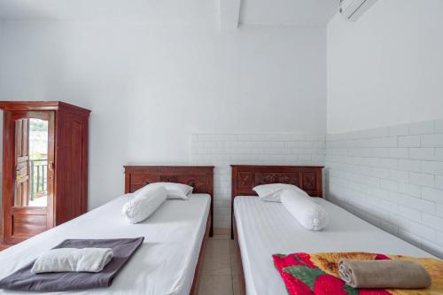 two beds sitting next to each other in a room at SDK Homestay Uluwatu in Uluwatu