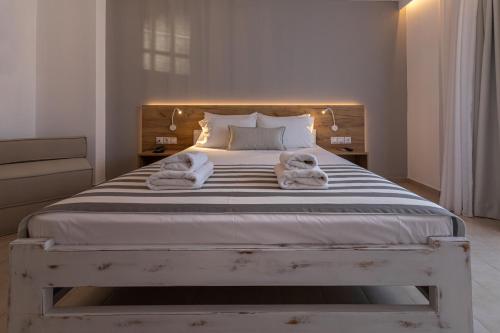 a bedroom with a large bed with towels on it at Triton Authentic Cretan Hotel in Tsoútsouros