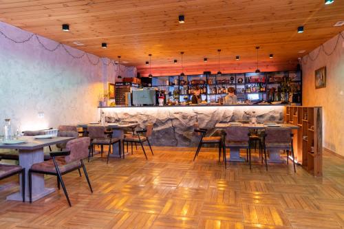 un restaurante con mesas y sillas y un bar en New Gudauri Rooms, en Gudauri