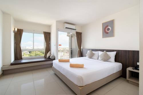 een slaapkamer met een groot bed en een groot raam bij Leenova Hotel in Bangkok